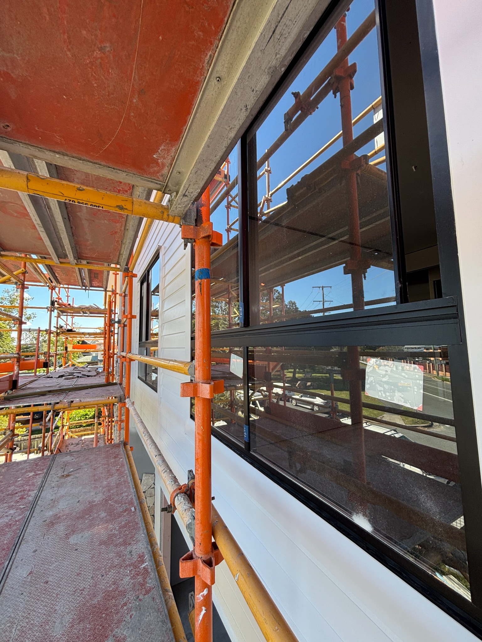 Black-framed windows beside scaffolding at a TheZenith construction cleaning job