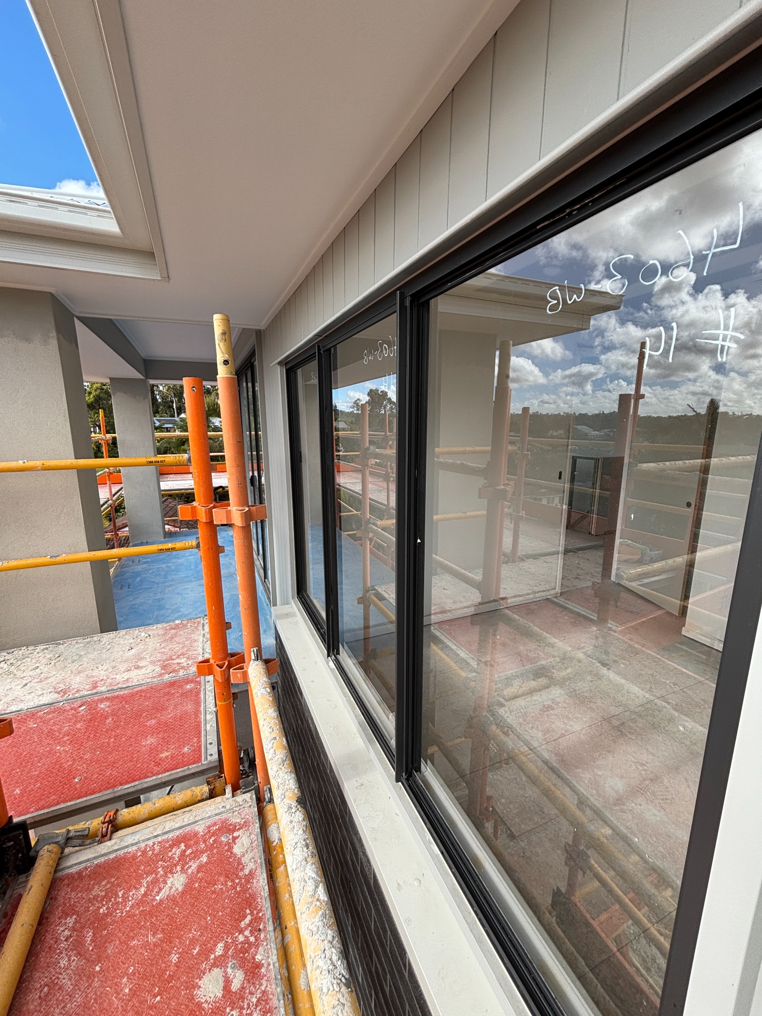 Large windows with construction markings beside exterior scaffolding